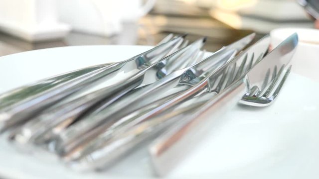 Empty white plate and cutlery on it. fork and knife. slow motion