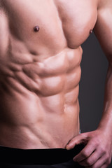 Naklejka premium Man bodybuilder, muscular guy. Male model. Athletic man with chest, abs, six pack. Naked torso. Athlete young handsome personal fitness trainer. Bodybuilder fitness model. Sexy portrait very muscular 