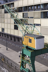 Crane with colored cabin and building as a background