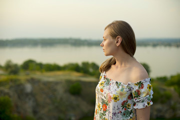 Half length portrait of charming positive woman is looking epically off into the distance in sunset...