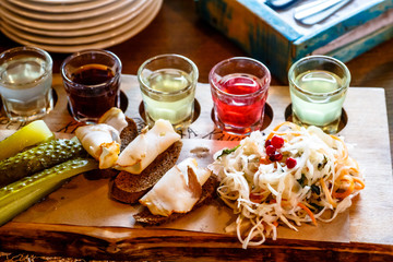 Traditional Russian snacks: cabbage, cucumbers and alcoholic drinks are on the table.