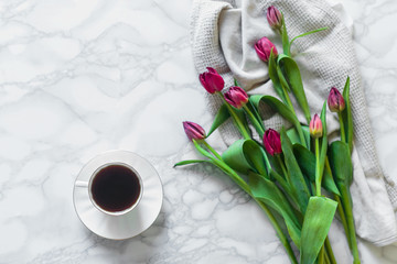 Cup of fresh coffee with red tulips on marble copyspace