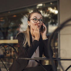 Fototapeta premium Business woman telling a secret by the phone