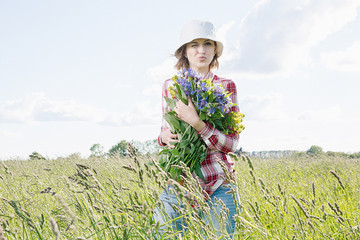 Girl with a basket of flowers in the field.