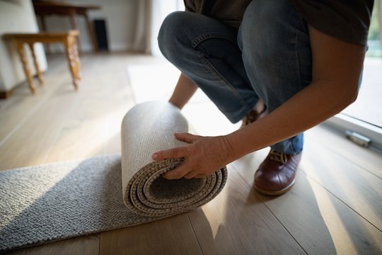 Woman rolling a carpet at home
