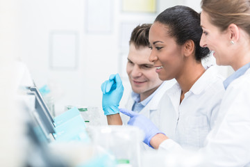 Group of researchers during work on devices in laboratory doing experiment