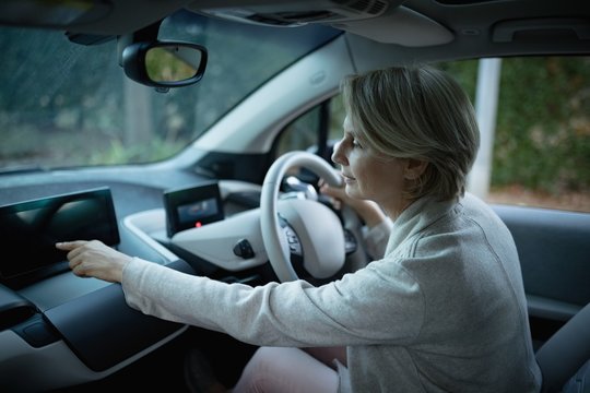 Woman using digital tablet while driving car