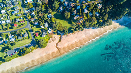Aerial view on small suburb on a sunny ocean beach. Coromandel peninsula, New Zealand