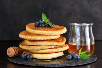 Homemade oat pancakes with honey and blueberries for breakfast on a stone plate. Good morning!