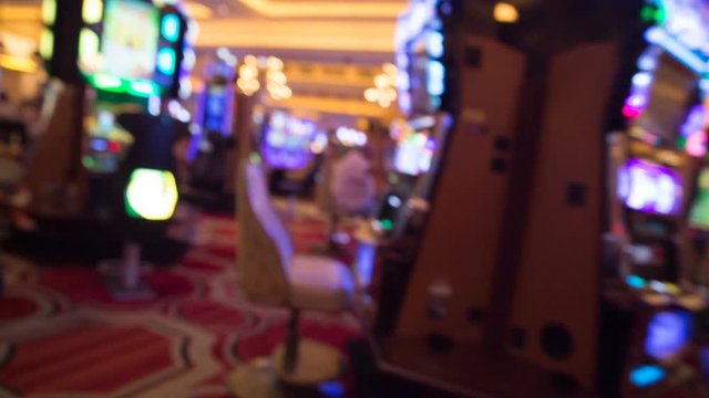 Blurred Walk Through Slot Machine Area Casino Floor. point of view of someone walking through a casino floor with games and slot machines all around
