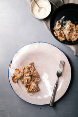 Cooked chanterelle mushrooms with sour cream sauce. Hand-made ceramic plate, rustic concept.