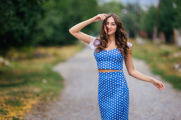 Fashion woman portrait of young pretty trendy girl in retro style dress posing at the summer street