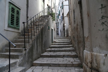 Fototapeta na wymiar Sibenik / Tourist city by the Adratic sea - Sibenik, Croatia. The old stones, narrow street and stairs.