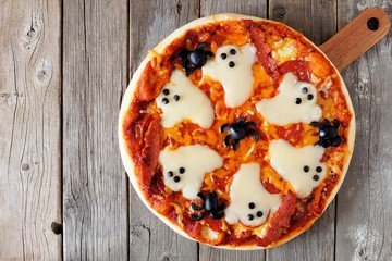Halloween pizza overhead view on a rustic wooden background