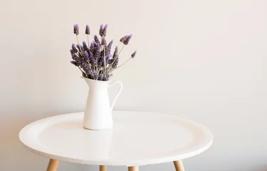 Stickers meubles Lavande Lavande pourpre dans une petite cruche blanche sur une table ronde contre un mur neutre