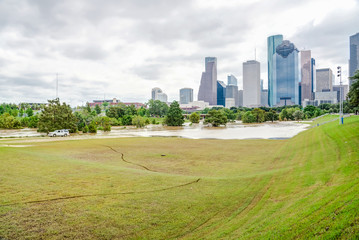 Obraz premium Downtown Houston at daytime with storm cloud sky and rare high water flood on Eleanor Park because of Harvey Tropical Storm. Heavy rains from hurricane Harvey caused many flooded areas in Houston