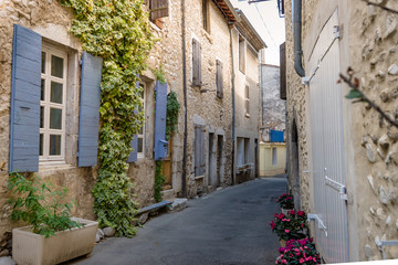 Fototapeta na wymiar Authentic French town with narrow streets, colorful houses and atmospheric flowers.