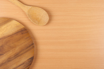 ladle and round cutting board on wooden table background, with copy space 