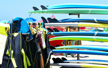 Surfboards and uniforms on the beach at the surf school