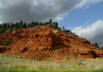 Red rock of Wyoming, with prairie grass and beautiful skis. Geology of the area includes many types of rock.