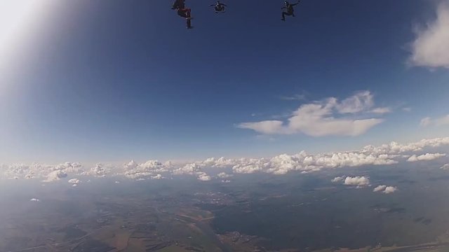 Professional skydivers in uniform free falling in sky. Hold balance. Sunny. Adrenaline.