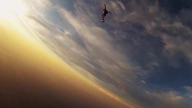 Team of professional skydivers jump from airplane fall in sky. Balance. Sunset. Extreme stunt