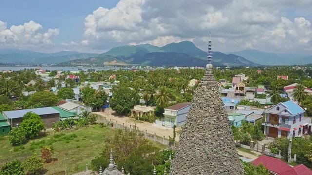 City among Palms behind Coral Buddhist Temple Tower
