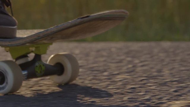 Skateboarder rolling next to wheat field with epic sunset and sun flares - shot on RED 4k Super Slow Motion