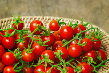 Fresh cherry tomato on wood basket.Close up lovely cherry tomato for background or wallpaper.Prepare fresh cherry tomato for home cooking look so delicious.Top view concept of cherry tomato in basket.