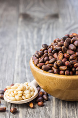 Pine nuts on wooden background. Selective focus, space for text.