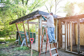 Homeowners tearing down an addition on a house