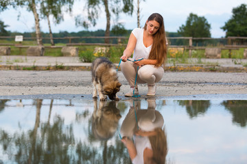 young woman with an elo puppy at a puddle