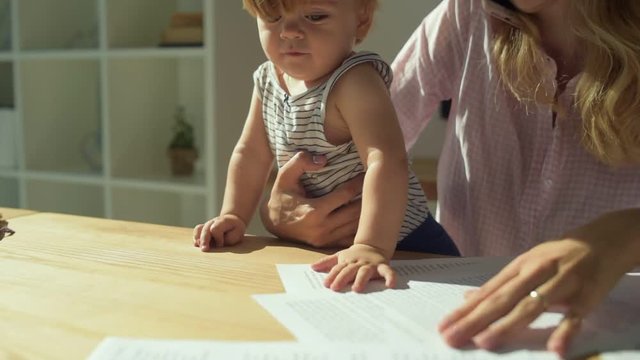 Cute child messing the papers in the room