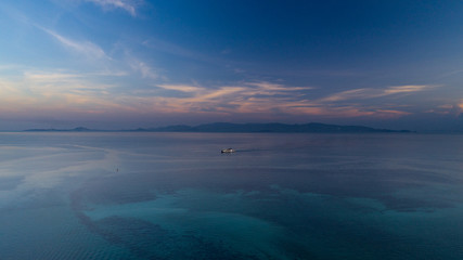Obraz premium sunset aerial view of clear blue sea with ferry boat 