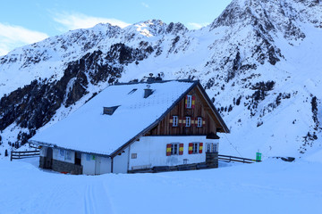 Alpine hut Potsdamer Hutte and mountain panorama with snow in winter in Stubai Alps, Austria