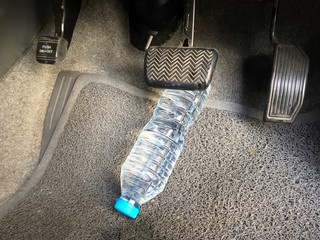 Water bottle getting stuck in the car accelerator and brake peddle demonstrating the danger of the...