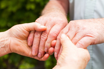 Elderly couple holding hands