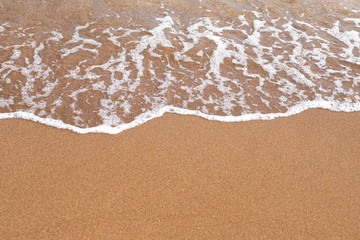 Sand beach. A sea wave on yellow sand. Abstract marine background.