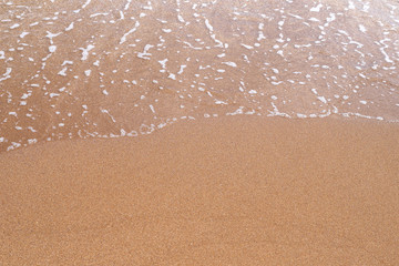 Fototapeta na wymiar Sand beach. A sea wave on yellow sand. Abstract marine background.
