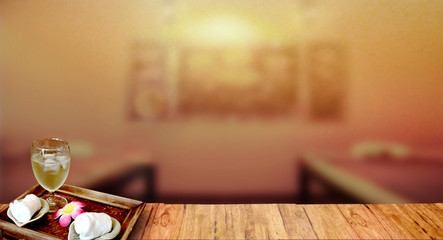 Towels in basket and ice green tea in glass  on top wood table with blurred spa massage room  background. For Graphic and Product display montage.  relaxing heath care  Concept.