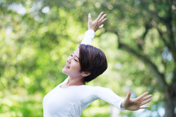 Young happy Asian woman exercising at the park.