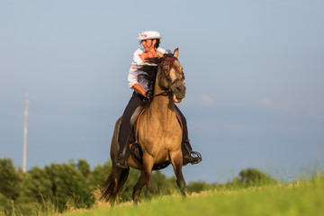 mature woman riding an Andalusian horse