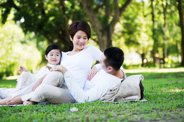 Young happy Asian family spending time together at the park.