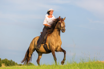 mature woman riding an Andalusian horse