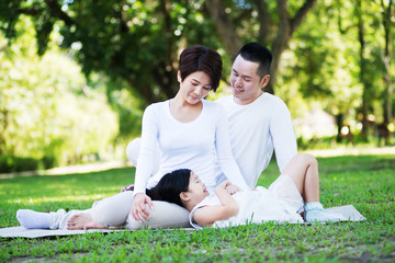 Young happy Asian family spending time together at the park.