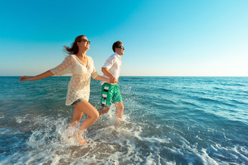 Obraz premium Happy young couple enjoying the sea