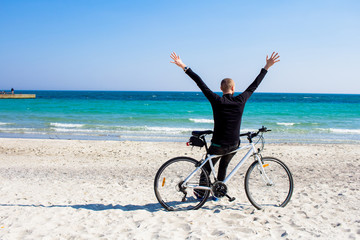 Fototapeta na wymiar Bicycle rider relaxing on the beach in good weather 