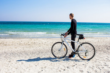 Fototapeta premium Bicycle rider relaxing on the beach in good weather 