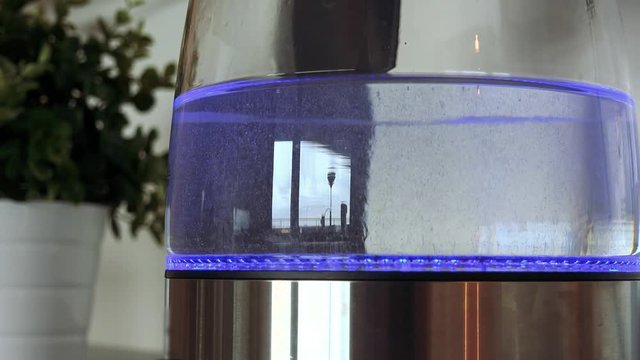 Water in a glass kettle boils - closeup