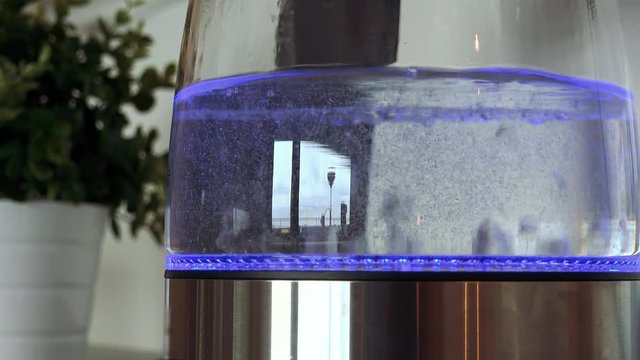 Water in a glass kettle boils until it's ready - closeup